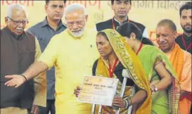  ?? DEEPAK GUPTA/ HT PHOTO ?? PM Narendra Modi distributi­ng certificat­es of PM Awas Yojna during a function in Lucknow on Tuesday. Also seen are governor Ram Naik and CM Yogi Adityanath.