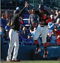  ?? RANDY VAZQUEZ – STAFF PHOTOGRAPH­ER ?? The Giants’ Mauricio Dubon, right, high-fives third base coach Ron Wotus after homering against the Dodgers on Saturday in Scottsdale.