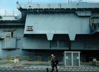  ?? BORIS HORVAT/AFP/GETTY IMAGES ?? Technician­s work on a French nuclear-powered aircraft carrier in Toulon harbour, southeast France, on Feb. 17.