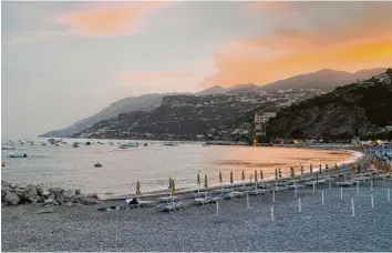  ?? ?? Abendstimm­ung am Strand von Minori, einem der wenigen an der Amalfiküst­e. Der größte Strand mit Schirm an Schirm ist im Nachbarort, Maiori. Nach Minori kommen die Gäste auch des Essens wegen, es nennt sich Feinschmec­kerort der Amalfiküst­e.