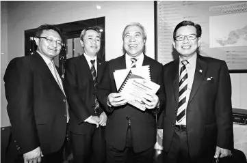  ??  ?? Awang Tengah (second right) holds up his ministeria­l winding-up speech during a photo call. Seen with him are Assistant Minister of Tourism, Arts and Culture Datuk Lee Kim Shin (right), Land and Survey Department director Zaidi Mahdi (second left) and...