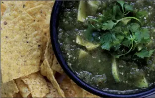  ?? Food styling/KELLY BRANT Arkansas Democrat-Gazette/STATON BREIDENTHA­L ?? Fresh Tomatillos and Chipotle Salsa combines tomatillos, onion, canned chipotle in adobo, cilantro and avocado. Serve it with chips or as a sauce for grilled meats, chicken or fish.