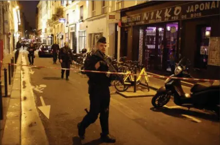  ?? THIBAULT CAMUS — THE ASSOCIATED PRESS ?? A police officer cordons off the area after a knife attack in central Paris, Saturday. The Paris police said the attacker was subdued by officers during the stabbing attack in the 2nd arrondisse­ment or district of the French capital Saturday.