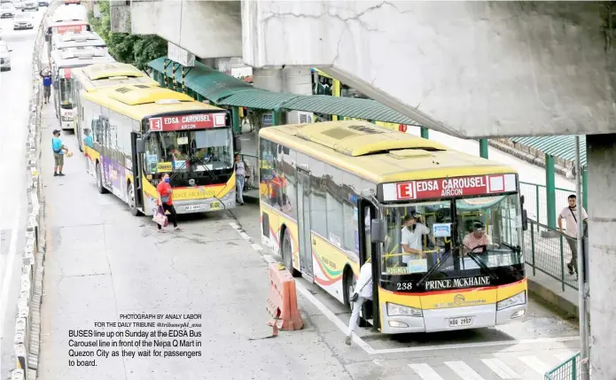  ?? ?? PHOTOGRAPH BY ANALY LABOR FOR THE DAILY TRIBUNE @tribunephl_ana BUSES line up on Sunday at the EDSA Bus Carousel line in front of the Nepa Q Mart in Quezon City as they wait for passengers to board.