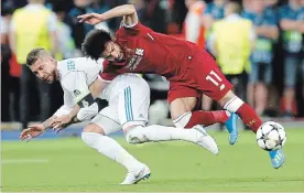  ?? ASSOCIATED PRESS FILE PHOTO ?? In this May 26 photo, Real Madrid’s Sergio Ramos, left, fouls Liverpool’s Mohamed Salah during the Champions League soccer final in Kyiv.