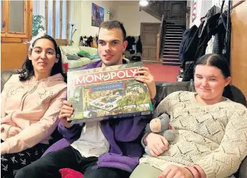  ??  ?? Game on Camphill residents Natasha, Charlie and Rachel ready to play Monopoly