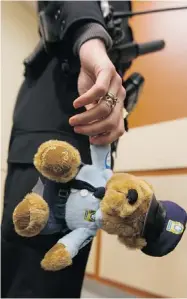  ?? JOHN MAHONEY/ THE GAZETTE ?? Officers respond to suspected domestic violence calls by giving children a teddy bear.