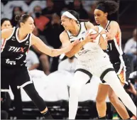  ?? Ralph Freso / Associated Press ?? The Sky’s Candace Parker, right, looks to pass as Mercury guard Diana Taurasi defends during the first half on Sunday.