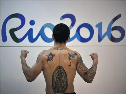  ?? YURI CORTEZ/AFP/GETTY IMAGES ?? Argentina’s Ignacio Perrin shows off his tattoos after a boxing training session at the Riocentro complex in Rio de Janeiro ahead of the Rio 2016 Olympic Games. Boxing nations in the Americas are pouring big financial support into their programs.