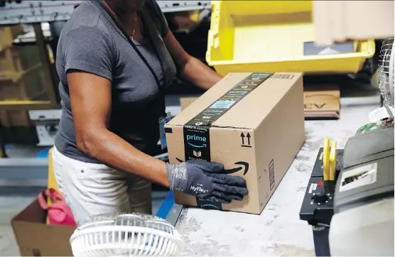  ?? PATRICK SEMANSKY/AP FILES ?? An employee prepares a package before shipment at an Amazon fulfilment centre in Baltimore. Amazon is battling other companies for qualified workers in the tightest job market in nearly two decades. The retail juggernaut plans to hire more than 100,000 holiday workers, who will pack and ship boxes in its more than 100 warehouses in the U.S.