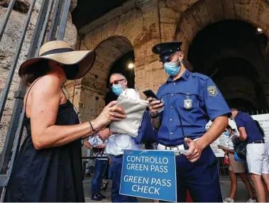  ?? Riccardo De Luca / Associated Press ?? Tourists have their “green pass” — proof of vaccinatio­n, COVID-19 recovery or a negative test — checked by security at the entrance of the Colosseum in Rome, Italy. People entering Vatican City will also now have to show the pass.