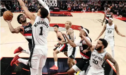  ?? Photograph: Steph Chambers/Getty Images ?? Scoot Henderson of the Portland Trail Blazers drives to the rim as Victor Wembanyama of the SanAntonio Spurs defends during the third quarter of last week’s game at the Moda Center.