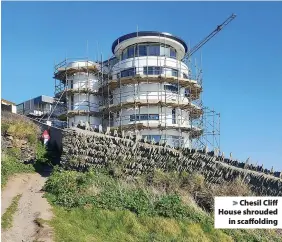  ??  ?? > Chesil Cliff House shrouded in scaffoldin­g