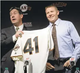  ?? ERIC RISBERG/ASSOCIATED PRESS ?? Mark Melancon receives a new jersey from Giants general manager Bobby Evans on Friday.