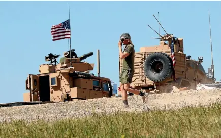  ?? PHOTO: AP ?? An American soldier walks on a newly installed base near the tense front line between the United States-backed Syrian Manbij Military Council and Turkish-backed fighters, in Manbij, northern Syria.