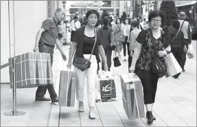  ?? REUTERS ?? Chinese tourists carry packages of Panasonic Corp’s washlet along Tokyo’s Ginza shopping district.