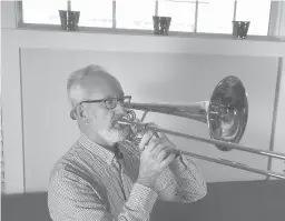  ?? BRAD HORRIGAN/HARTFORD COURANT ?? Bill Whitaker plays his bass trombone at his West Hartford home. Whitaker has regularly played on Broadway since 2002, but he doesn’t expect shows to return in NewYork City until next fall.