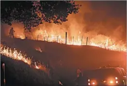  ?? NOAH BERGER/AP ?? Fire crews set a backfire to battle a raging wildfire near the town of Mariposa, Calif.