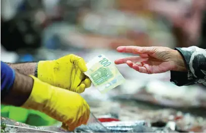  ?? EFE ?? Una mujer paga en una pescadería de La Coruña