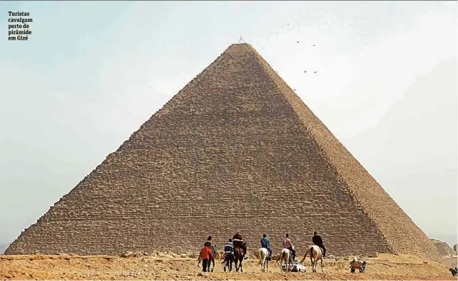  ??  ?? Turistas cavalgam perto de pirâmide em Gizé