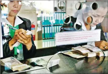  ?? SUPPLIED ?? Tellers conduct business at a microfinan­ce institutio­n in Phnom Penh.