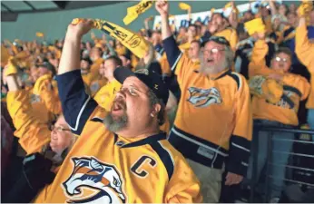  ?? TOM STANFORD, THE (NASHVILLE) TENNESSEAN ?? Jeff Miller, front, and Predators fans are wearing gold jerseys and basking in the playoff run.