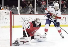  ?? JULIO CORTEZ AP ?? Devils goalie Keith Kinkaid block a shot as Aleksander Barkov waits for the puck nearby.