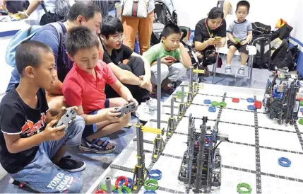  ?? Photo: Xinhua ?? Children control robots at the 2018 World Robot Conference in Beijing, capital of China, on August 16, 2018.