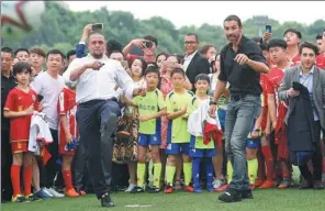  ?? LI GA/ XINHUA ?? Retired soccer stars Roberto Carlos (left) of Brazil and Robert Pires of France demonstrat­e their moves for young players in Changsha, Hunan province, on Friday. Important names in the soccer world are in the city for the World Football Forum, which...