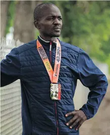  ?? DAVID ROSSITER/ CALGARY HERALD ?? Daniel Kipkoech wears his finisher’s medal prior to a training session in Lethbridge, Tuesday. He was disqualifi­ed in last weekend’s Scotiabank Calgary Marathon. Kipkoech was on track for a time that would have placed him second overall.