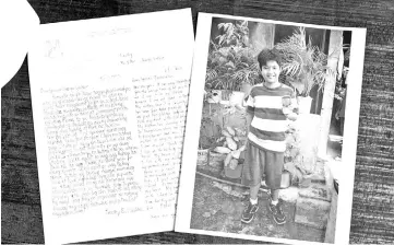  ?? — AFP photo ?? File photo shows a picture of Timothy, then a 7-year-old Filipino boy, with a letter he sent to his pen pal Bush who sponsored him for 10 years using a pseudonym.