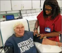 ?? PETE BANNAN — DAILY LOCAL NEWS ?? Red Cross staffer Ada Moore check Paul Olson’s blood pressure before he gives his 600th blood donation to the American Red Cross. He is wearing a shirt from his alama mater, Gustavus Adolphus College in St. Peter, Minnesota.