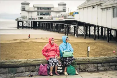  ??  ?? Two ladies sit on the seafront promenade at Weston-super-Mare