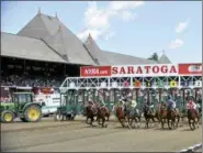  ?? AP FILE ?? Horses are set to break from the starting gate during opening day of season at Saratoga Race Course in Saratoga Springs, N.Y.