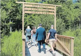  ?? RACHEL EMMANUEL THE ST. CATHARINES STANDARD ?? Family and friends of Troy Larouche walk through Heartland Forest to visit his memorial plaque.