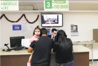  ?? Gregory Bull / Associated Press ?? An official at the Mexican consulate in San Diego helps a family Friday. Mexico has begun an effort to provide assistance to immigrants in the United States who fear deportatio­n.