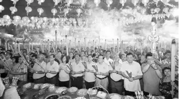  ??  ?? The temple committee leads the crowd in the worship of deity Ti Kong at the stroke of 12. Penghulu Soon is at fifth right, front row.