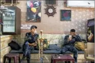  ?? ALEX POTTER — THE WASHINGTON POST ?? Iraqi Federal Police members take a break at the Captain pool hall in Mosul, Iraq, one smoking a water pipe and both checking their cellphones.