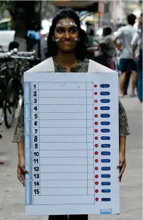 ?? — AFP ?? An art school student dressed as an electronic voting machine walks along a street in Mumbai to encourage people to vote in upcoming elections.