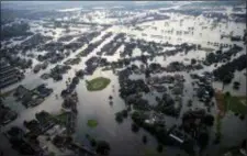  ?? GERALD HERBERT - THE ASSOCIATED PRESS ?? Floodwater­s from Tropical Storm Harvey surround homes in Port Arthur, Texas, in 2017. Advocacy groups say Texas is poised to unfairly distribute $5 billion in federal funding provided for housing repairs following Hurricane Harvey, prioritizi­ng wealthy...