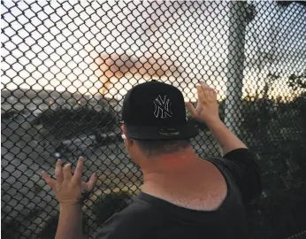  ?? Stephen Lam / Special to The Chronicle 2012 ?? A Richmond resident watches the Chevron refinery fire in August 2012.