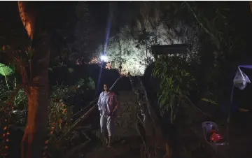  ?? — AFP photo ?? A Buddhist devotee walks down from the mouth of Tham Luang cave, at the Khun Nam Nang Non Forest Park in Chiang Rai province, as the rescue operation continues for a missing children’s football team and their coach.