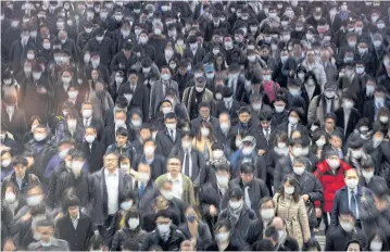  ?? REUTERS ?? Crowds wearing protective masks are seen at the Shinagawa station in Tokyo on Monday.