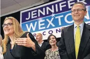  ?? [KATHERINE FREY/THE WASHINGTON POST] ?? Democrat Jennifer Wexton talks to supporters flanked by her husband, Andrew, Tuesday in Dulles, Va. Wexton beat incumbent Barbara Comstock in Virginia’s 10th congressio­nal district.