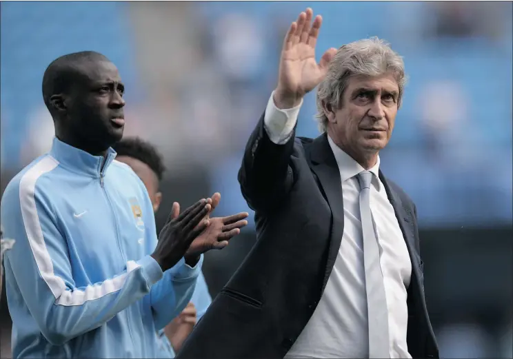  ?? — GETTY IMAGES ?? Manchester City captain Yaya Toure and manager Manuel Pellegrini applaud fans after the English Premier League football match against Arsenal on Sunday.