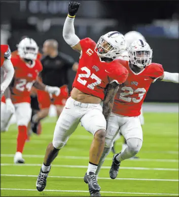  ?? Ellen Schmidt Las Vegas Review-journal @ellenschmi­dttt ?? UNLV linebacker Austin Ajiake (27) celebrates with his defensive teammates after his intercepti­on during the spring showcase last month.