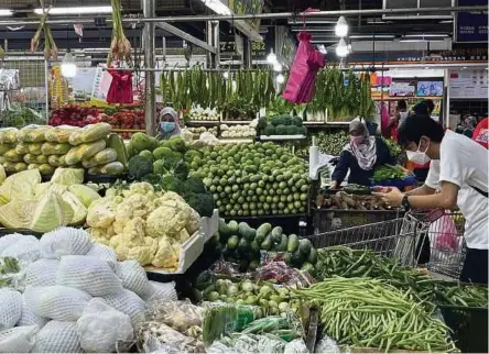  ?? (Foto Nur Aisyah Mazalan/bh) ?? Harga pelbagai sayur yang meningkat mengehadka­n perbelanja­an pengguna ketika tinjauan di basah di Pandan Johor Baru, semalam.