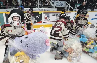  ?? CLIFFORD SKARSTEDT EXAMINER ?? Minor hockey players collect stuffed toys during the annual Teddy Bear Toss. Some 1,693 stuffed toys were collected, 300 more than last year.
