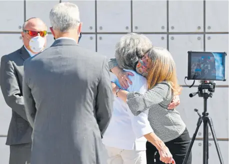  ?? Hyoung Chang, The Denver Post ?? Sigman, right, embraces mother-in-law Bobbe Cook during an interment service for Sigmna’s mother at Fort Logan National Cemetery.