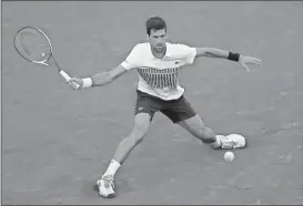  ?? Petr David Josek / The Associated Press ?? Novak Djokovic plays a shot against Albert Ramos-Vinolas during their fourth-round match of the French Open on Sunday at Roland Garros stadium in Paris, France.